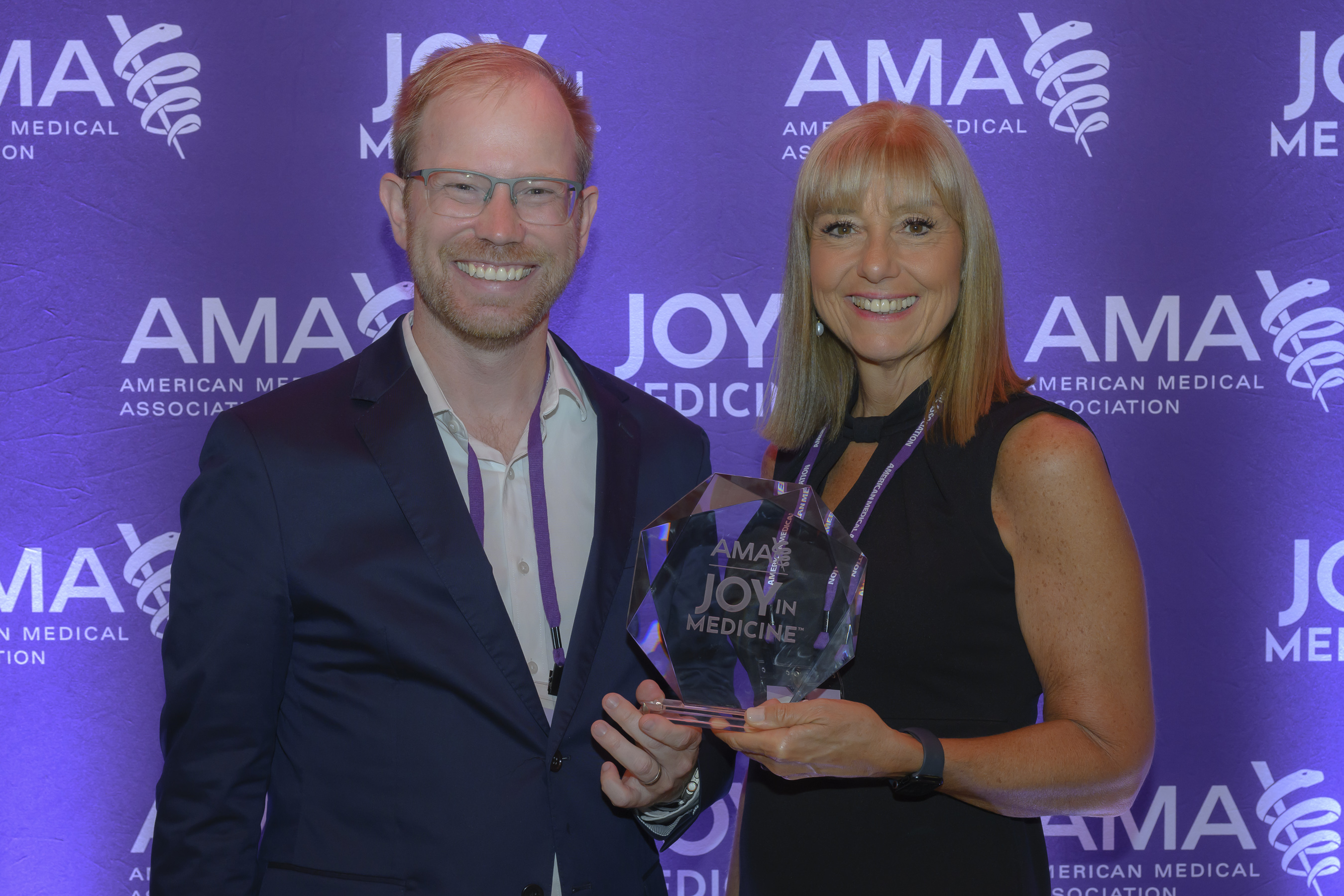 Samuel Ash, MD and Kimberly Dever, MD of South Shore Health pose for a photo with the AMA Joy in Medicine Award trophy.