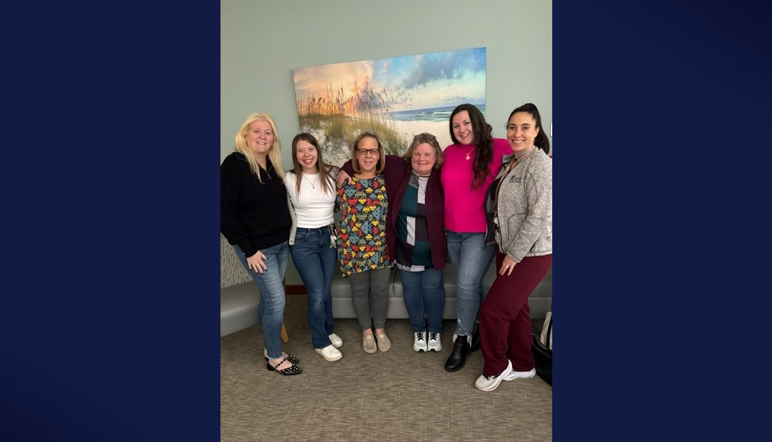 Photo of CCU colleagues from South Shore Health posing for a group shot on a navy background