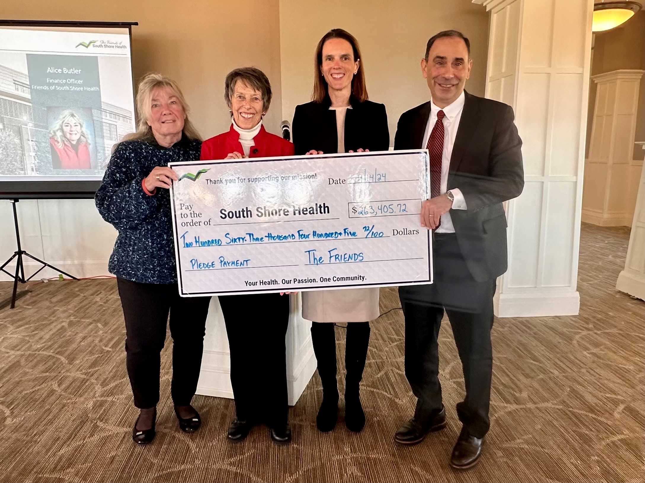 Allen Smith, Lauren Spencer pose with members of The Friends board and an oversized donation check.