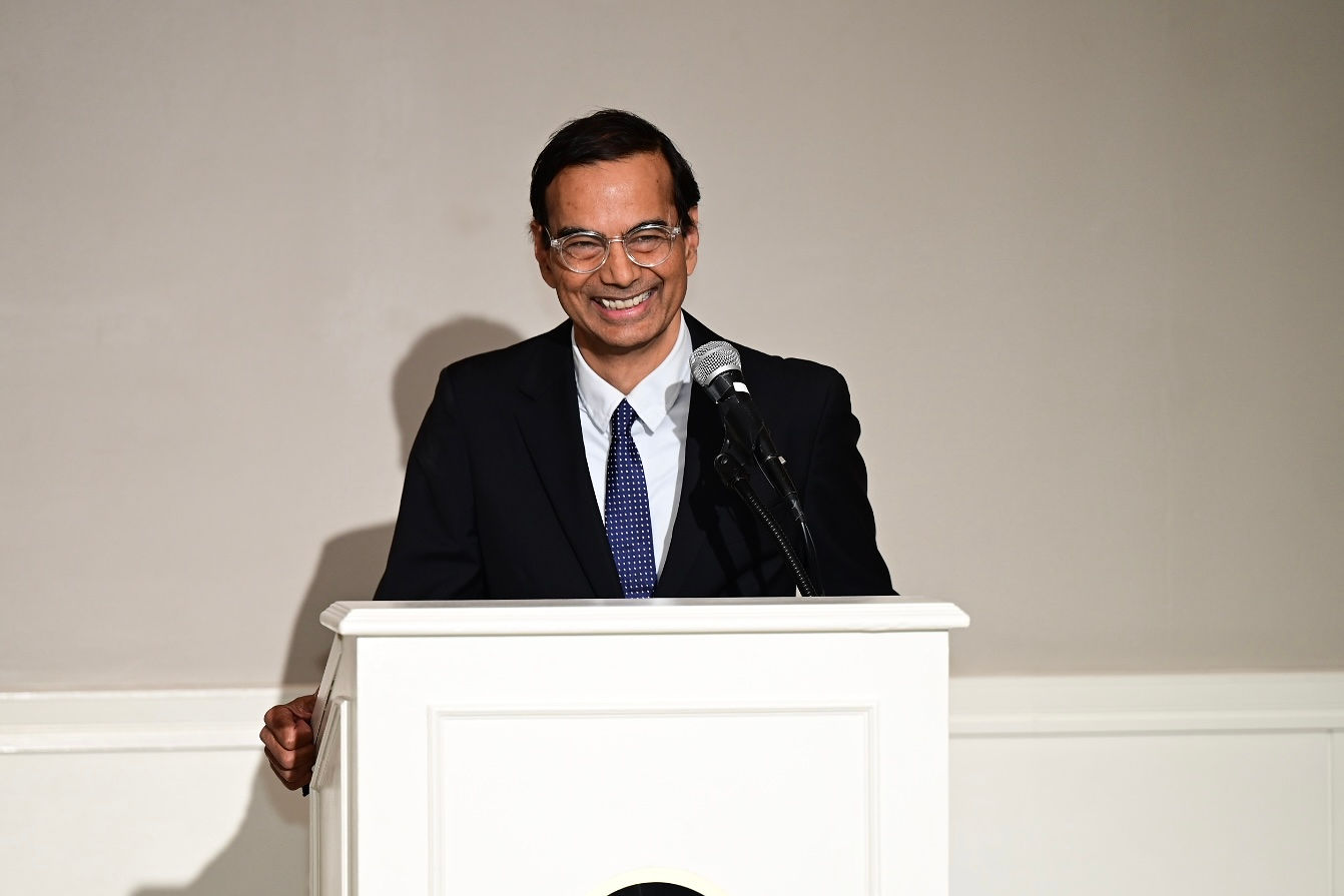 Baba Shetty smiles as he speaks from the podium during a reception in Hingham