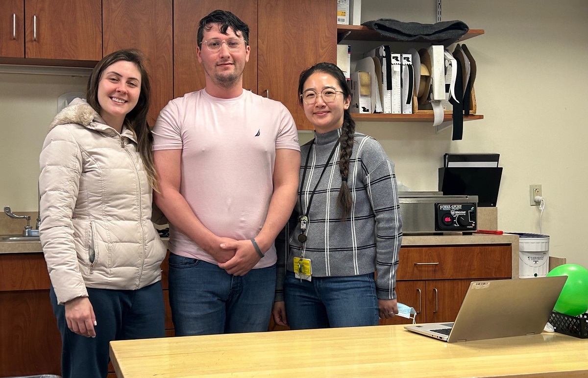 A woman and her husband stands with their female occupational therapist