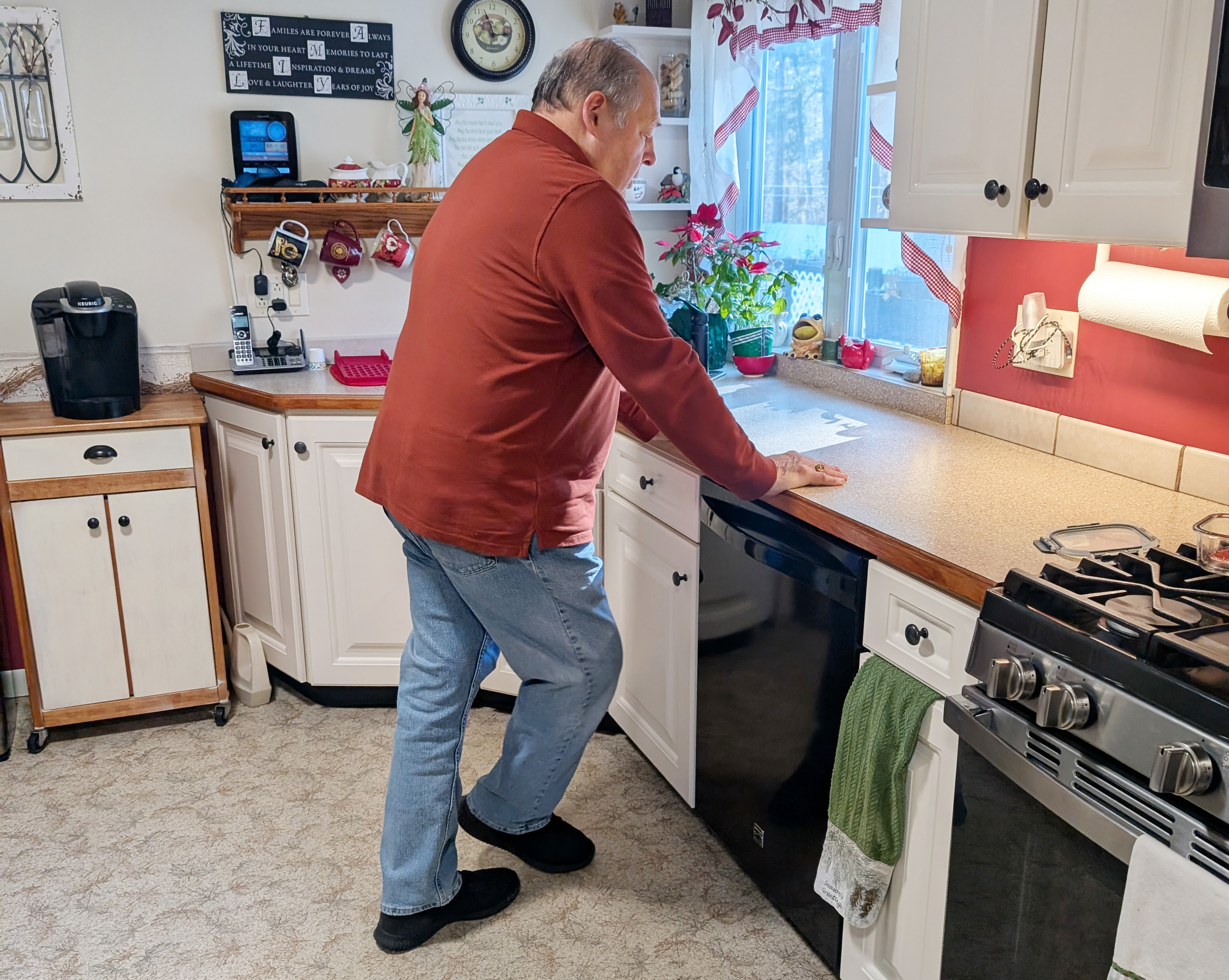 John of Rockland crosses one foot behind the other as he walks in his kitchen during an at-home rehab appointment.