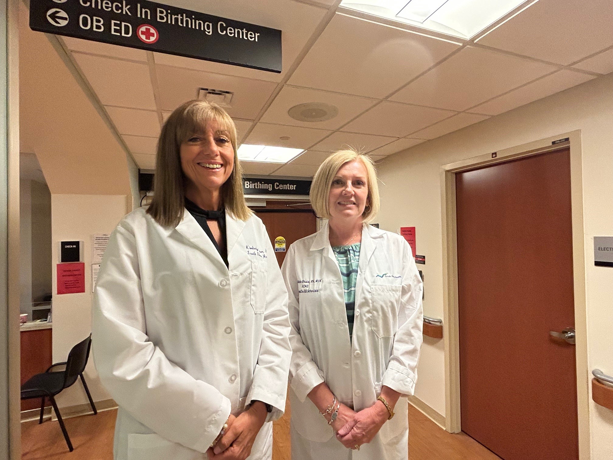 Kimberly Dever, MD and Kathleen Bruce stand outside the obstetrics emergency department