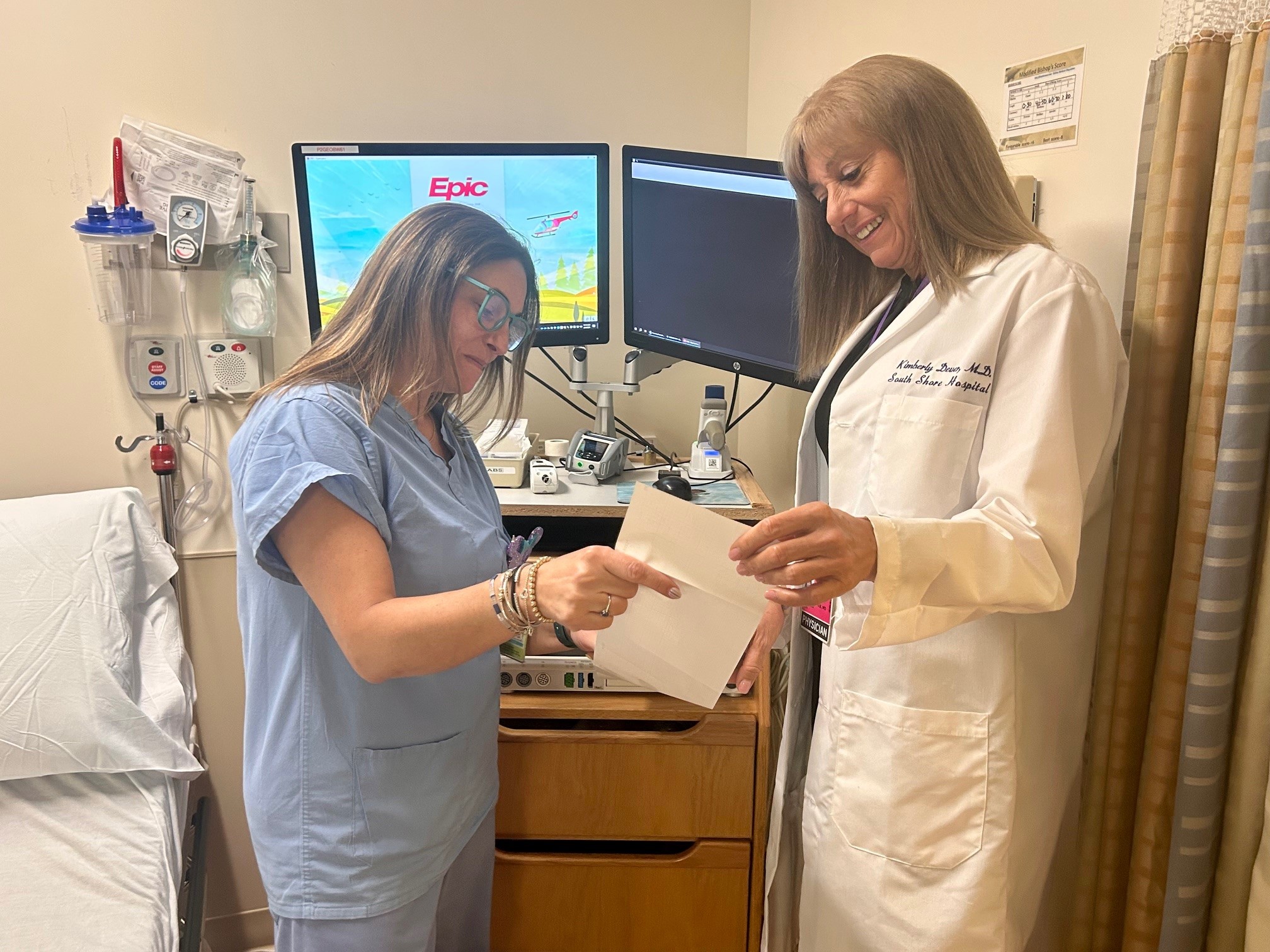 A nurse and doctor review report from a fetal monitor.