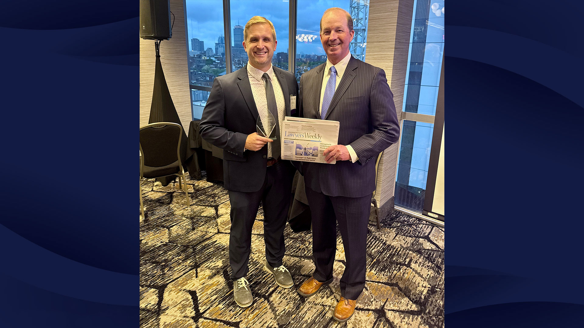 Photo of Lucas Hamory holding a glass award, next to Joseph Driscoll, holding a paper copy of Massachusetts Lawyers' Weekly