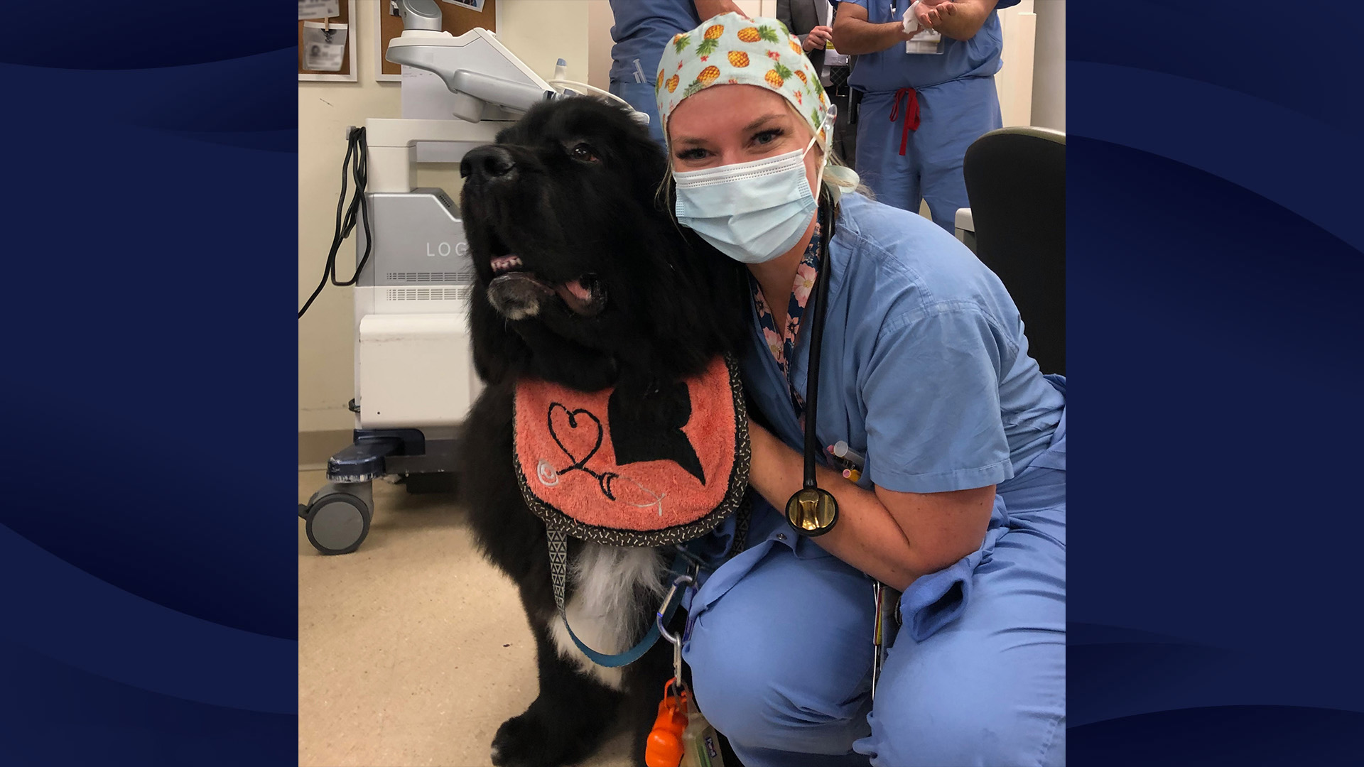 Taylor Micheroni, MD poses for a photo hugging her Newfie service dog, Luigi.