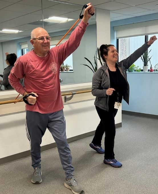 Peter Umile works out with exercise bands alongside his instructor, Jennifer Logan