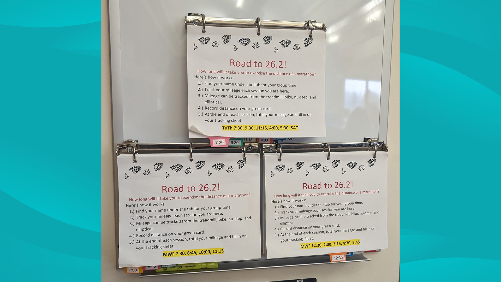 Three binders hanging on a wall containing tracking sheets for South Shore Health's 26.2 Challenge.