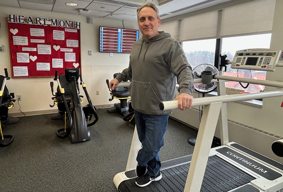 A cardiac rehab patient standing on a treadmill for photo