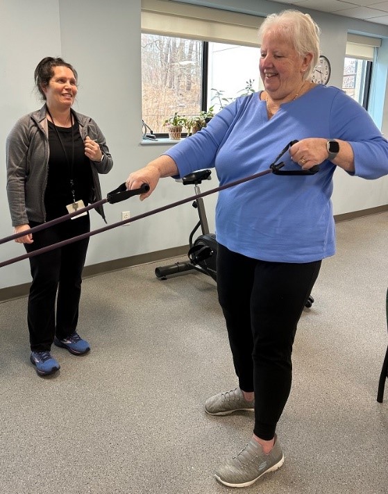 Sue Cullinan uses exercise bands in the Senior Strength Training Class as instructor Jennifer Logan looks on