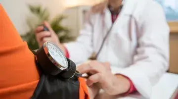 A clinician checks a patient's blood pressure