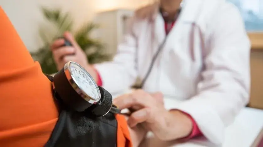 A clinician checks a patient's blood pressure