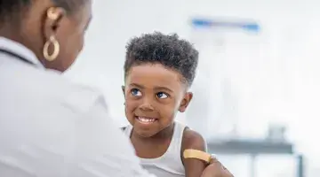 A young boy smiles after getting a vaccine