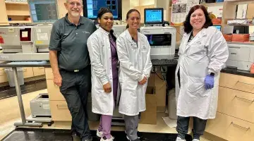 4 colleagues from South Shore Medical pose for a photo in front of the new Sysmex analyzer.