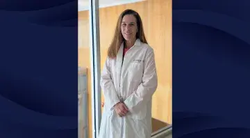 Photo of Alison Gustafson, MD of South Shore Health wearing a white lab coat. Photo is on a navy, wave-patterned background.