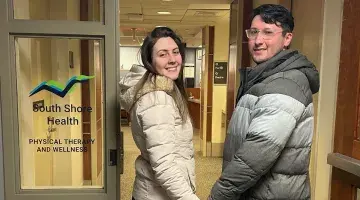 A woman and a man hold hands as they enter South Shore Health Physical Therapy and Wellness