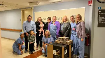 The Leong Family poses for a group photo with nurses and doctors from the South Shore Hospital NICU and their donated items.